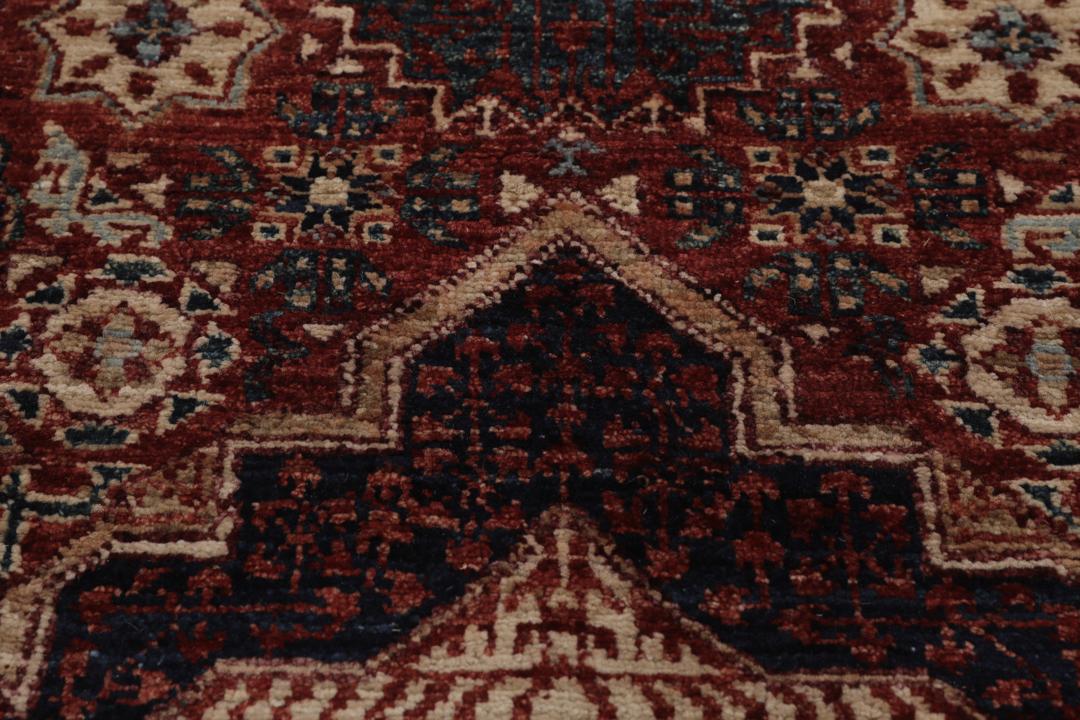 Et håndknyttet Mamluk-tæppe fra Afghanistan i røde og beige nuancer.