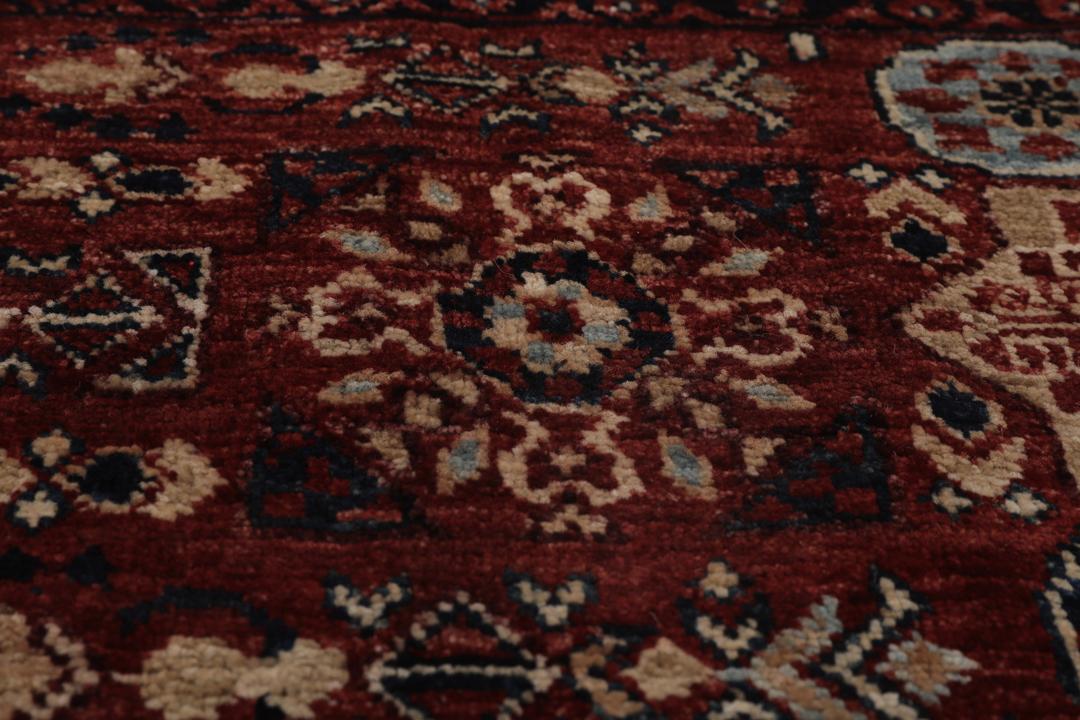Et håndknyttet Mamluk-tæppe fra Afghanistan i røde og beige nuancer.