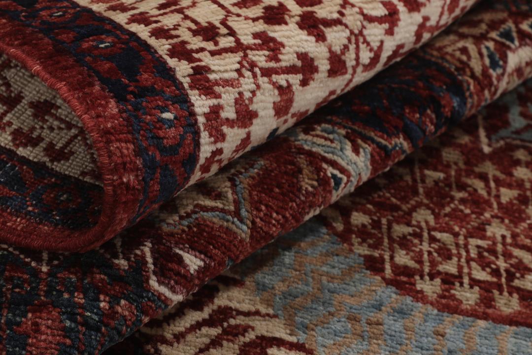 Et håndknyttet Mamluk-tæppe fra Afghanistan i røde og beige nuancer.