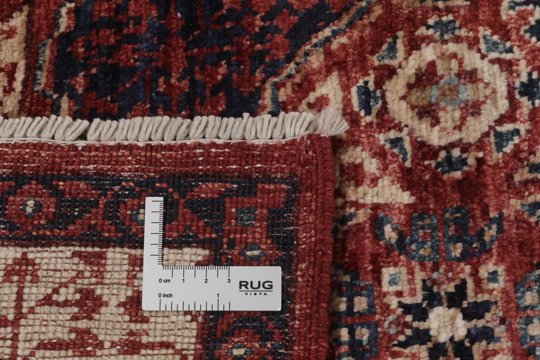 Et håndknyttet Mamluk-tæppe fra Afghanistan i røde og beige nuancer.