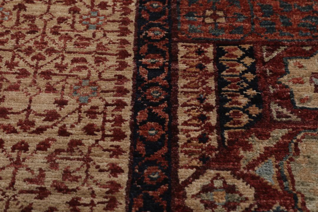 Et håndknyttet afghansk Mamluk-tæppe i rød og beige med geometriske medaljonmønstre.