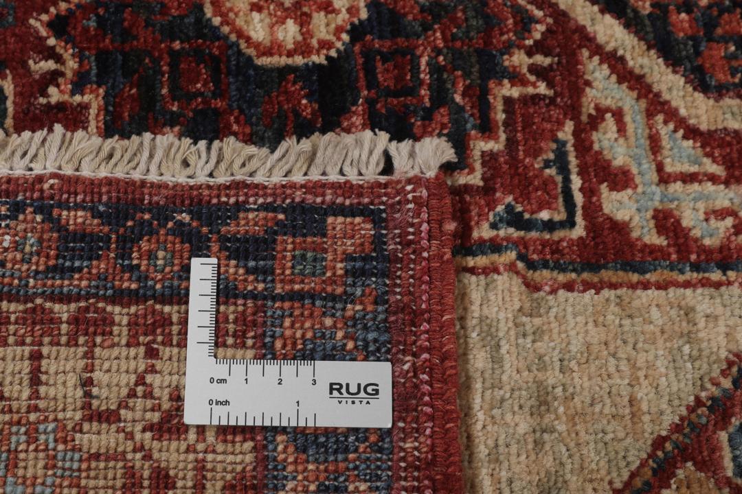 Et håndknyttet afghansk Mamluk-tæppe i rød og beige med geometriske medaljonmønstre.