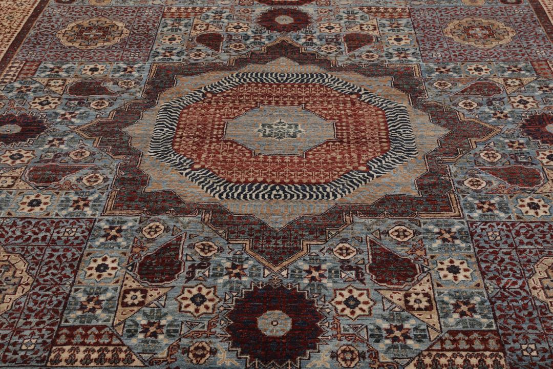Et håndknyttet Mamluk-tæppe fra Afghanistan med et rødt og blåt geometrisk mønster.