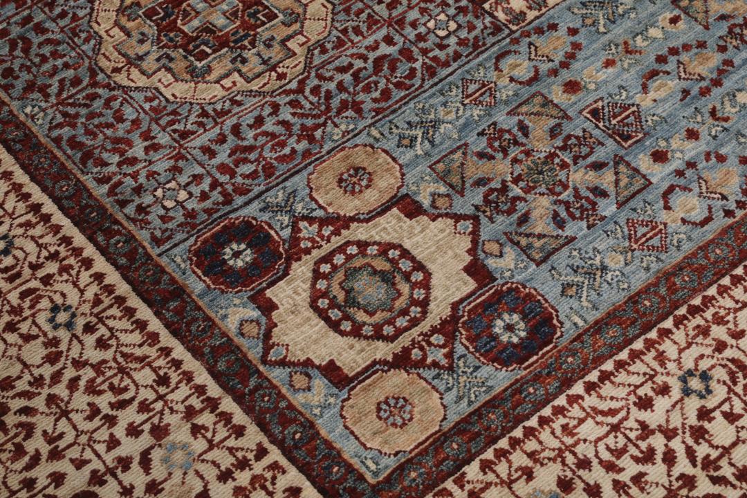 Et håndknyttet Mamluk-tæppe fra Afghanistan med et rødt og blåt geometrisk mønster.