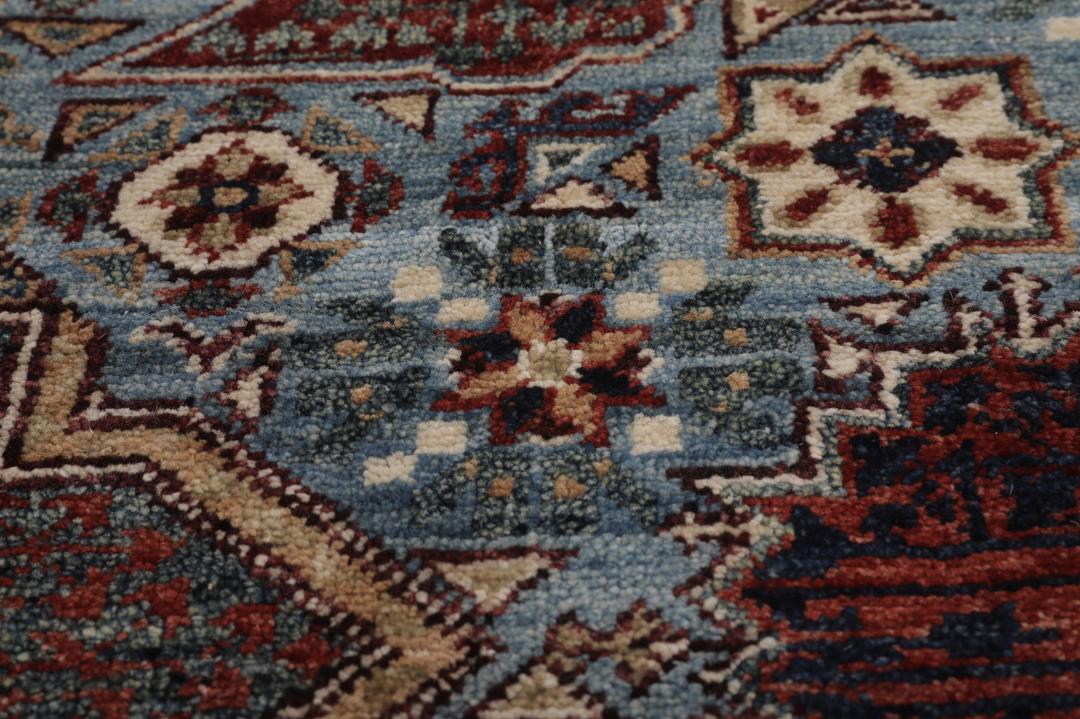 Et håndknyttet Mamluk-tæppe fra Afghanistan med et rødt og blåt geometrisk mønster.