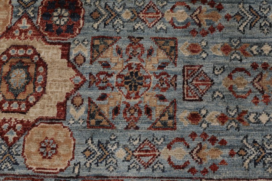 Et håndknyttet Mamluk-tæppe fra Afghanistan med et rødt og blåt geometrisk mønster.