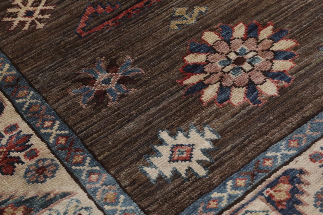 Un tapis Kazak afghan noué à la main avec un champ marron et des motifs tribaux géométriques.