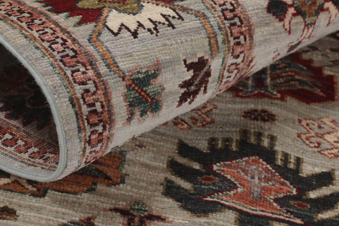 Tapis Kazak noué à la main originaire d'Afghanistan avec un fond gris et des motifs traditionnels.