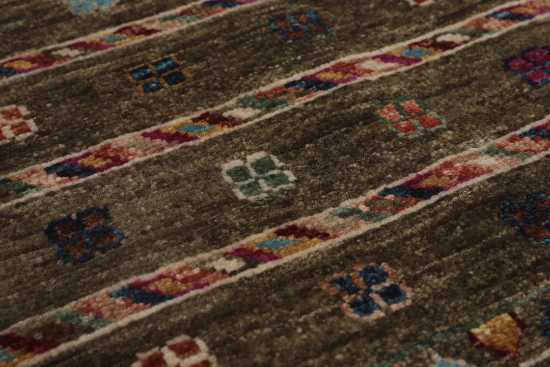 Alfombra afgana anudada a mano con patrones geométricos tribales en tonos marrones y multicolor