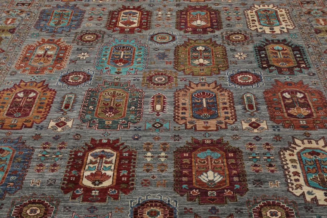 Alfombra de lana anudada a mano procedente de Afganistán con intrincados motivos multicolor sobre un fondo gris.