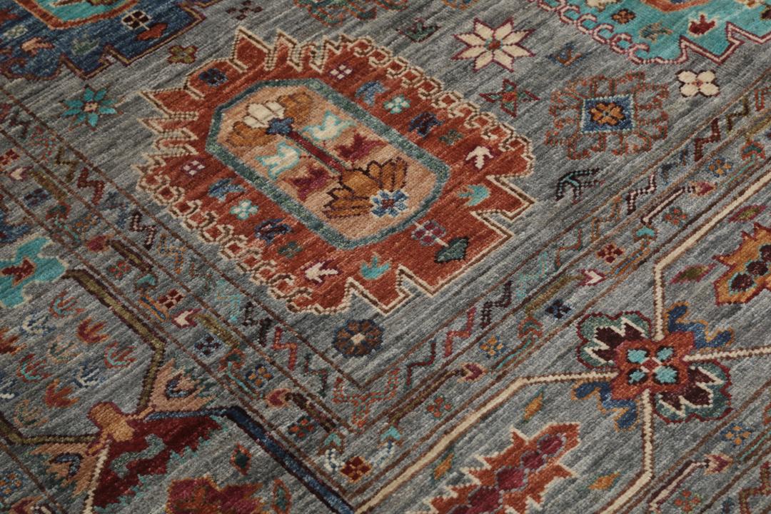 Alfombra de lana anudada a mano procedente de Afganistán con intrincados motivos multicolor sobre un fondo gris.