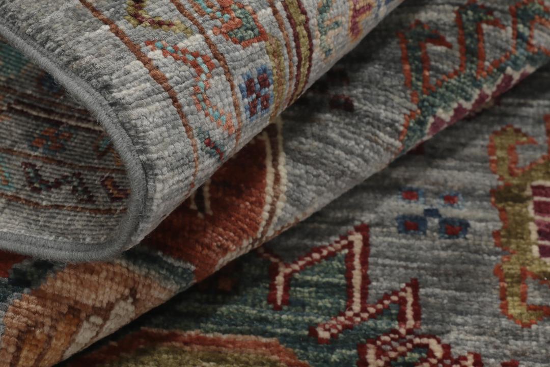 Alfombra de lana anudada a mano procedente de Afganistán con intrincados motivos multicolor sobre un fondo gris.