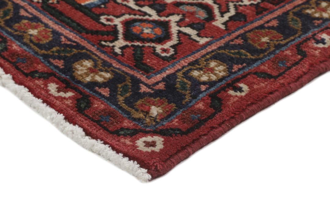 Hand-knotted Hosseinabad rug with red and dark-blue tones from the Middle East.