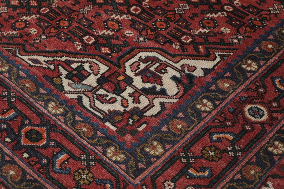 Hand-knotted Hosseinabad rug with red and dark-blue tones from the Middle East.