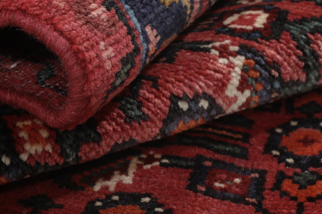 Hand-knotted Hosseinabad rug with red and dark-blue tones from the Middle East.