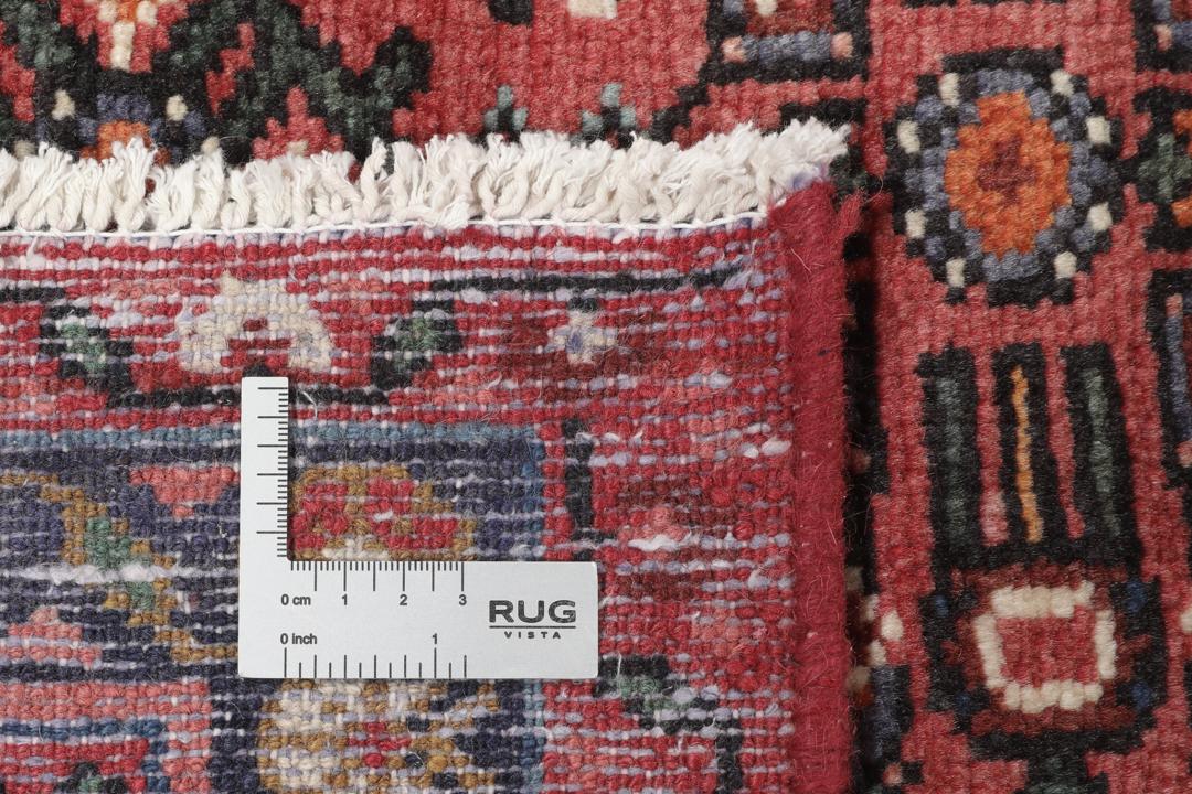 Hand-knotted Hosseinabad rug with red and dark-blue tones from the Middle East.