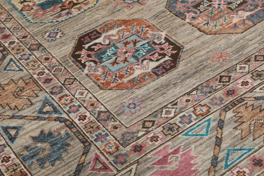 Un covor înnodat manual Kazak Ariana din Afganistan, cu motive geometrice colorate pe un fundal bej.