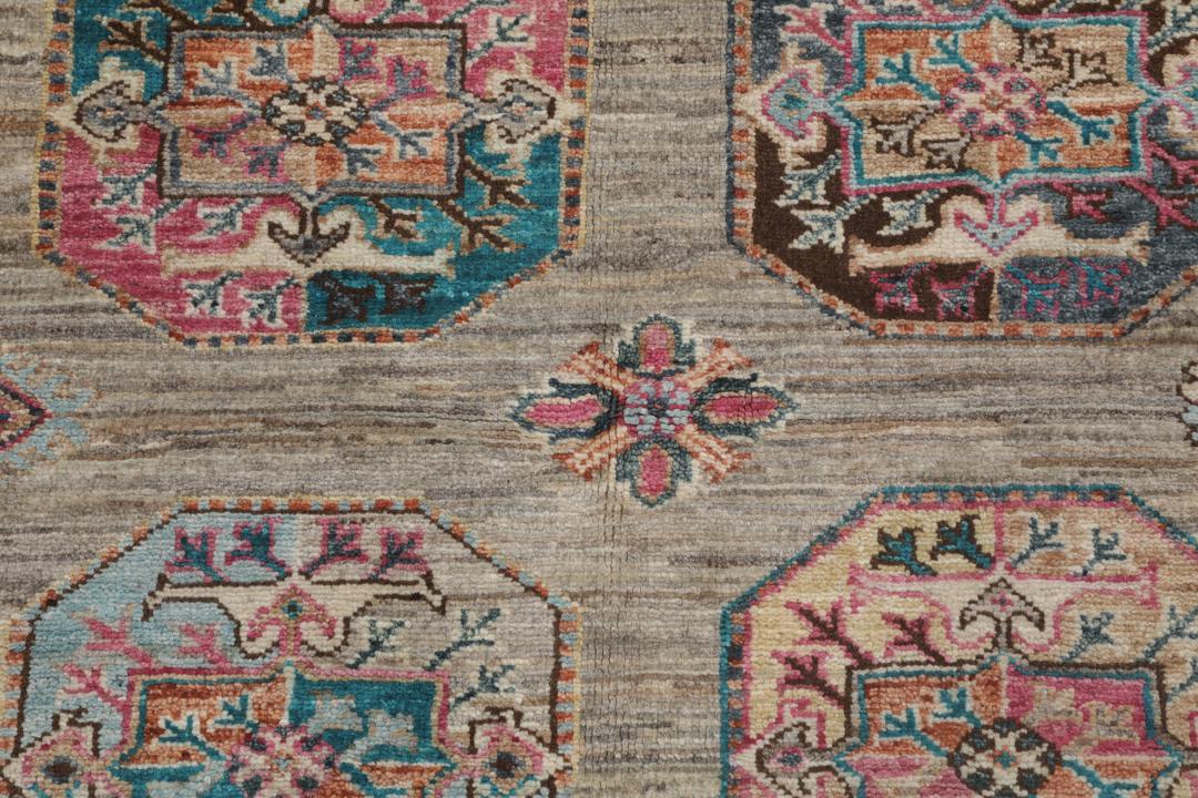 Un covor înnodat manual Kazak Ariana din Afganistan, cu motive geometrice colorate pe un fundal bej.