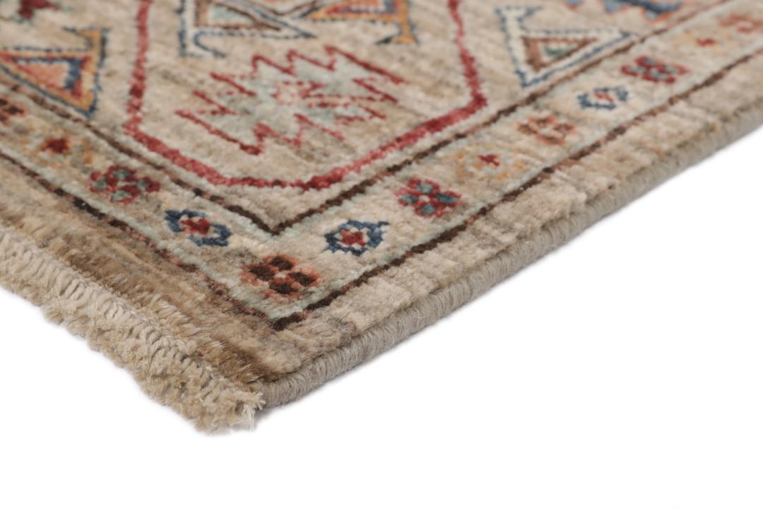 Una alfombra pasillera afgana anudada a mano con tonos beige y motivos de medallones.