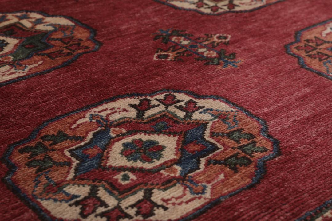 Handgeknoopt Kazak-tapijt uit Afghanistan in donkerrood met geometrische medaillonpatronen