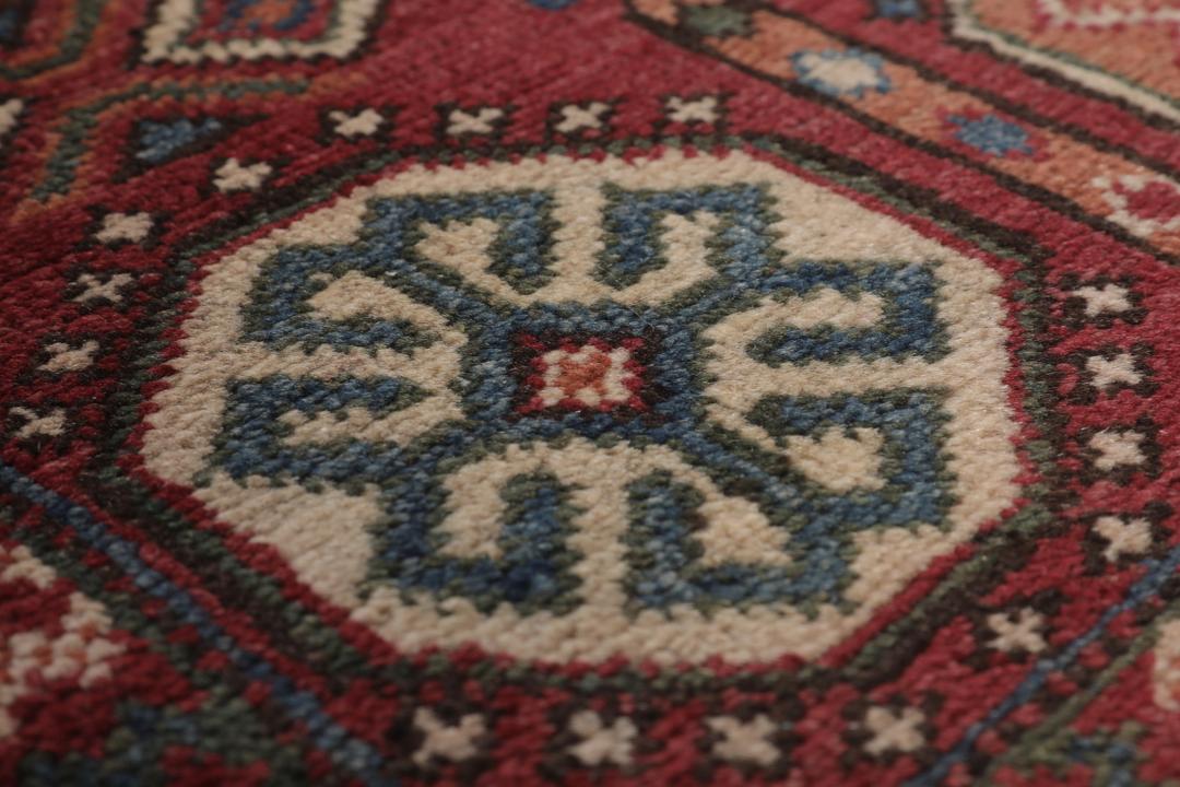 Handgeknoopt Kazak-tapijt uit Afghanistan in donkerrood met geometrische medaillonpatronen