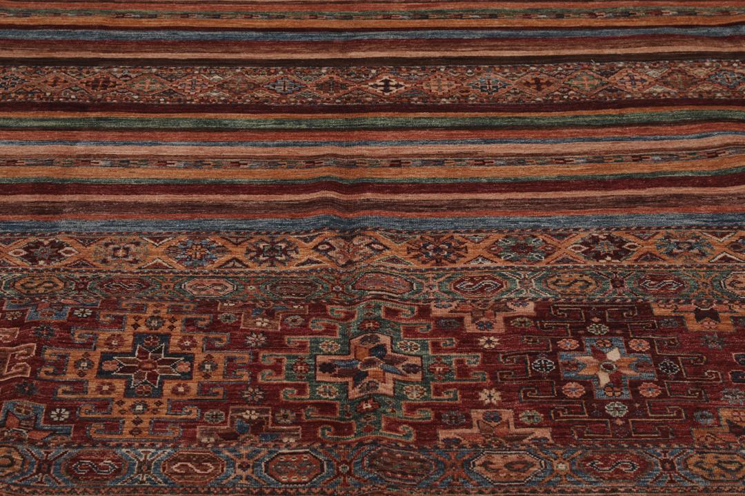 Alfombra afgana anudada a mano en multicolor con intrincados patrones de inspiración tribal.