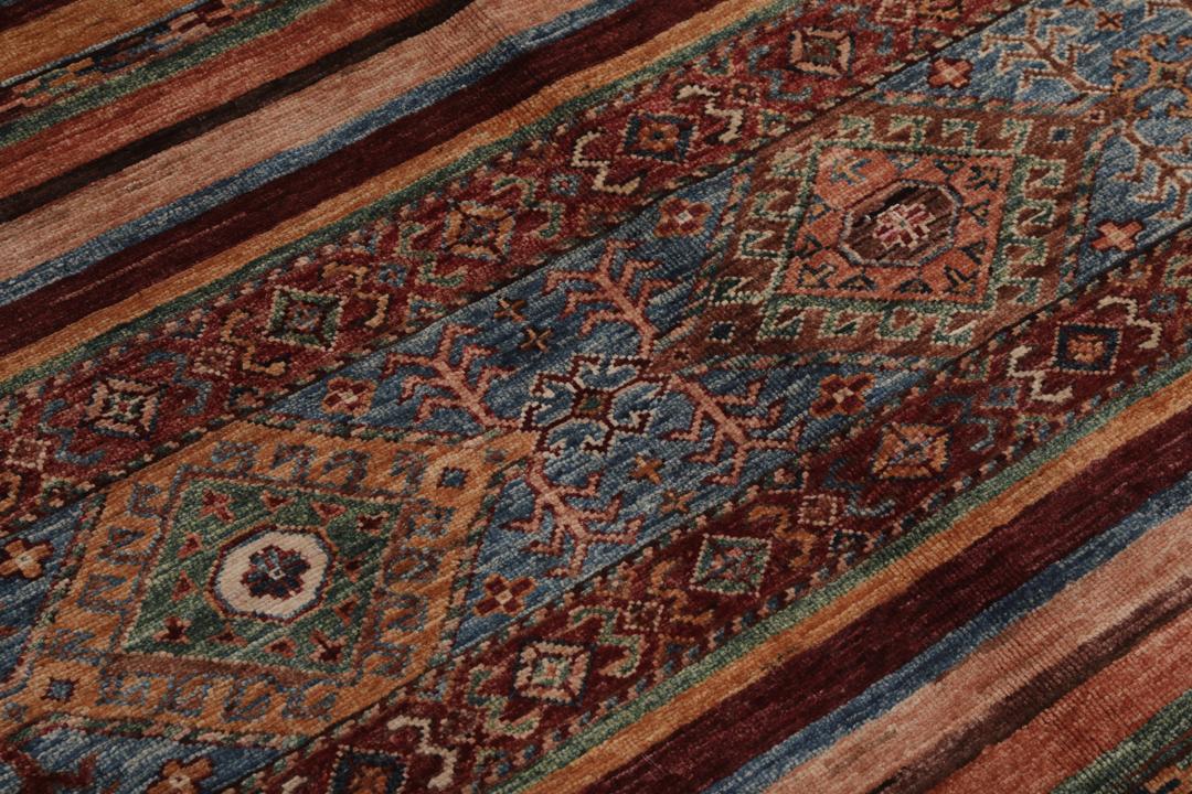 Alfombra afgana anudada a mano en multicolor con intrincados patrones de inspiración tribal.