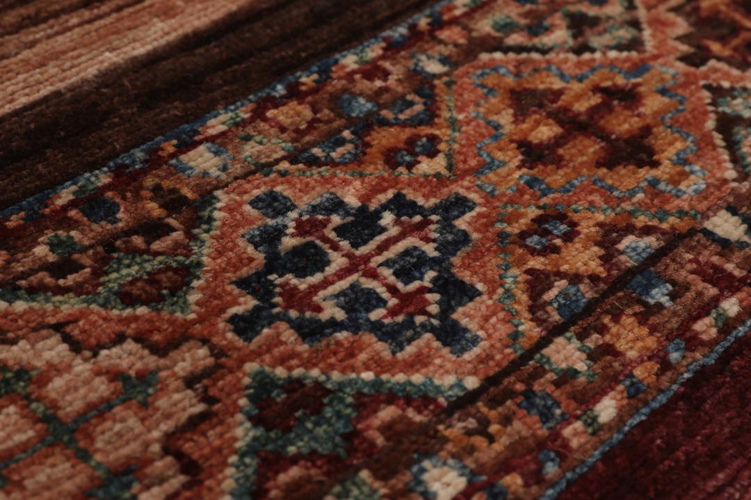 Alfombra afgana anudada a mano en multicolor con intrincados patrones de inspiración tribal.