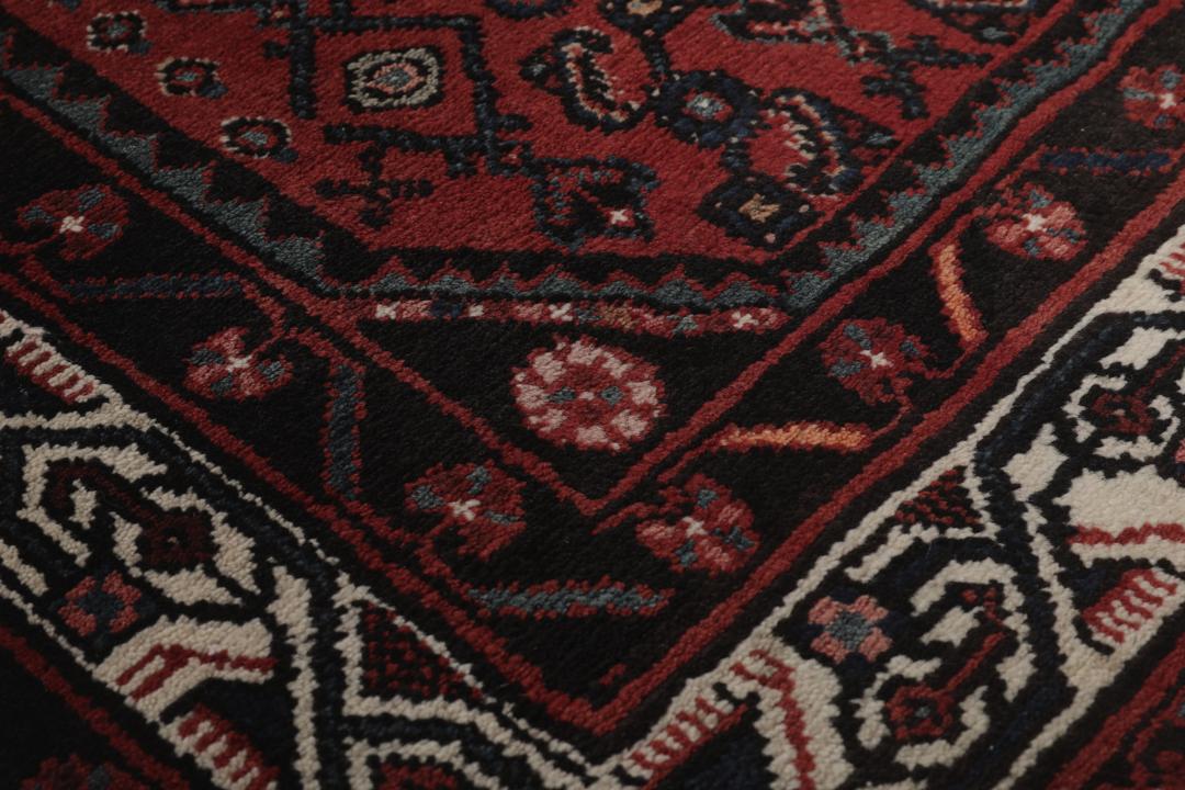 Handgeknoopt Hamadan-kleed uit het Midden-Oosten in donkerrode en zwarte tinten.