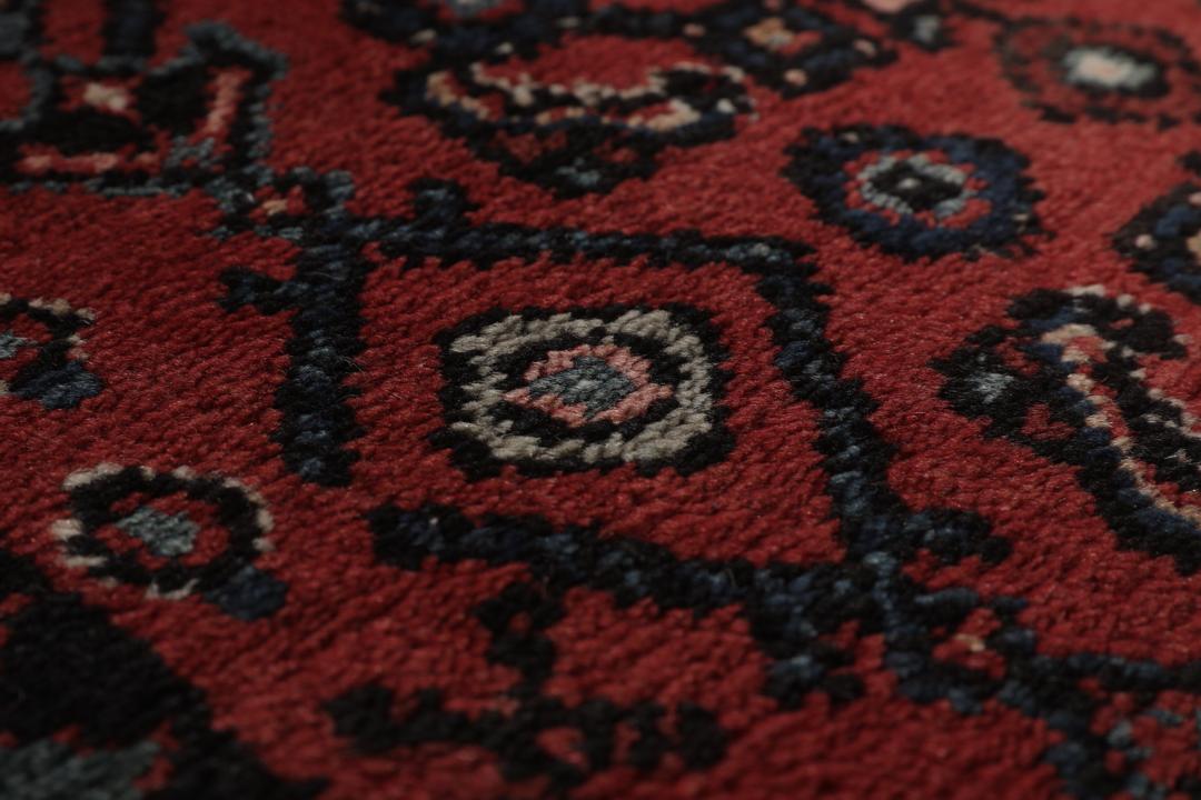 Handgeknoopt Hamadan-kleed uit het Midden-Oosten in donkerrode en zwarte tinten.