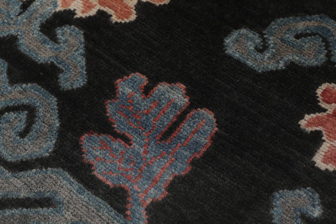 Tapis Kazak noué à la main avec un fond noir et des motifs floraux colorés