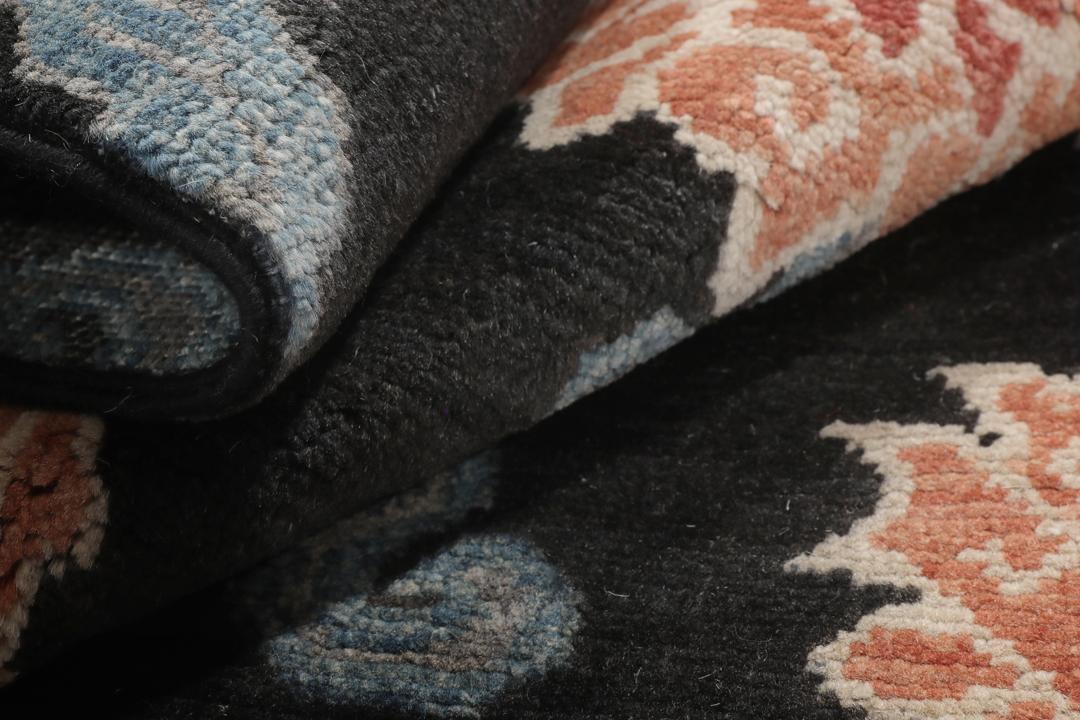Tapis Kazak noué à la main avec un fond noir et des motifs floraux colorés