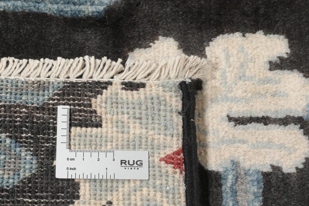 Tapis Kazak noué à la main avec un fond noir et des motifs floraux colorés