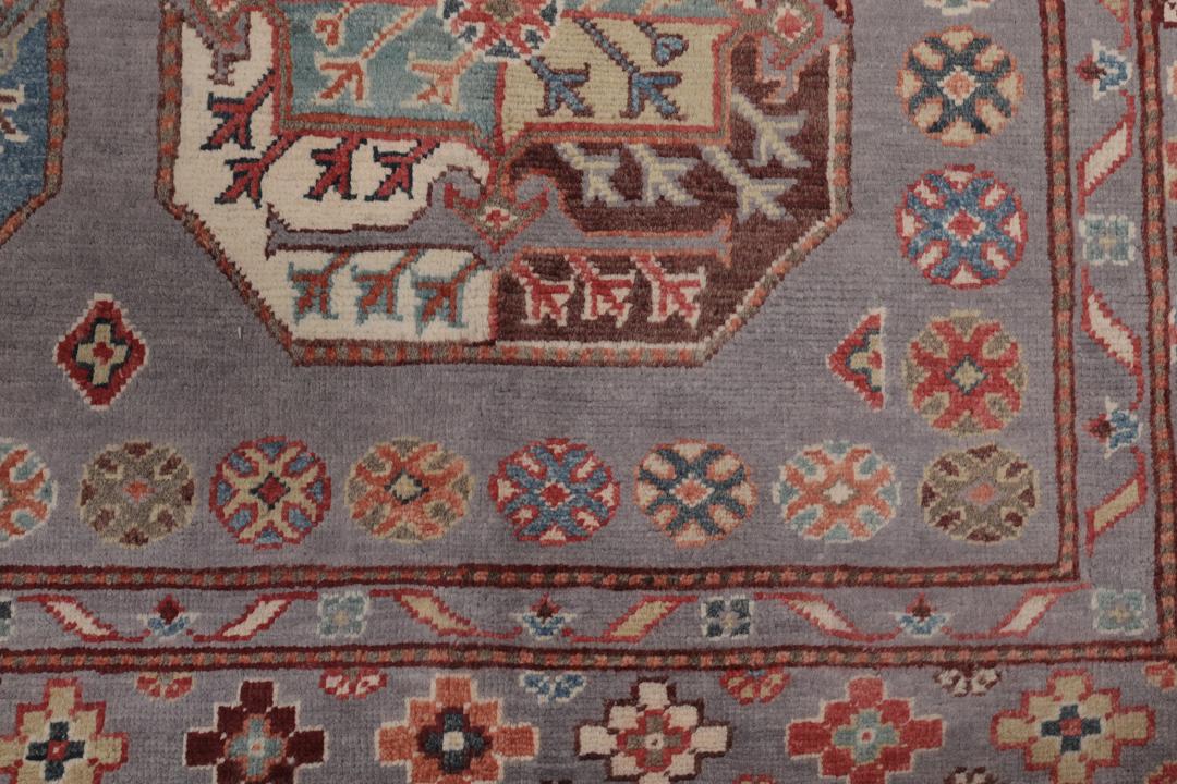 Hand-knotted Afghan Kazak rug with a grey field and geometric medallion motifs.
