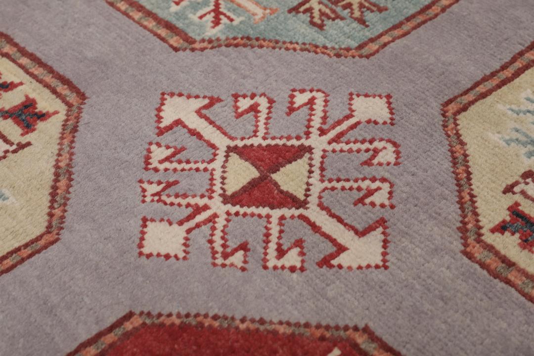 Hand-knotted Afghan Kazak rug with a grey field and geometric medallion motifs.