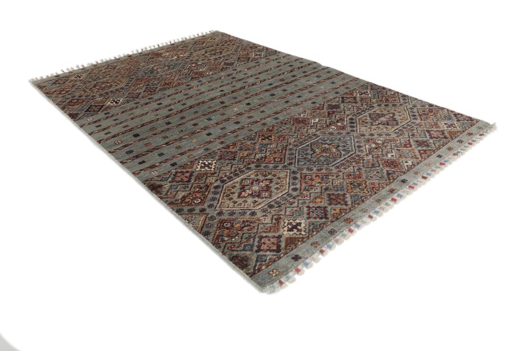 Una alfombra rectangular anudada a mano de Afganistán con una base verde y patrones geométricos