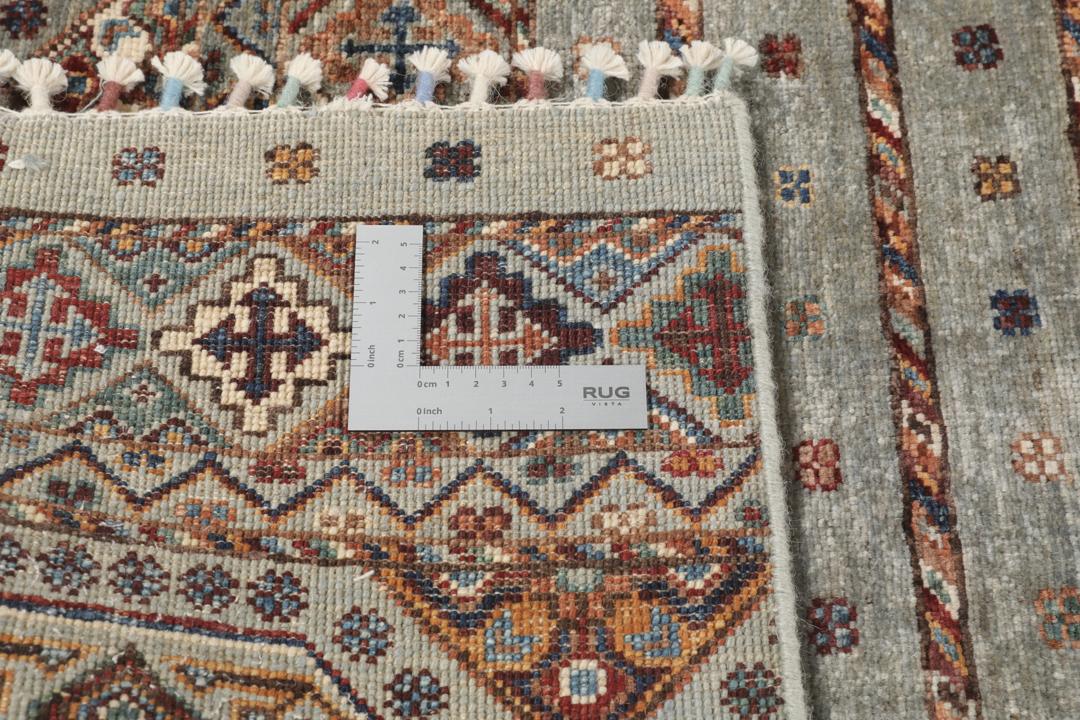 Una alfombra rectangular anudada a mano de Afganistán con una base verde y patrones geométricos