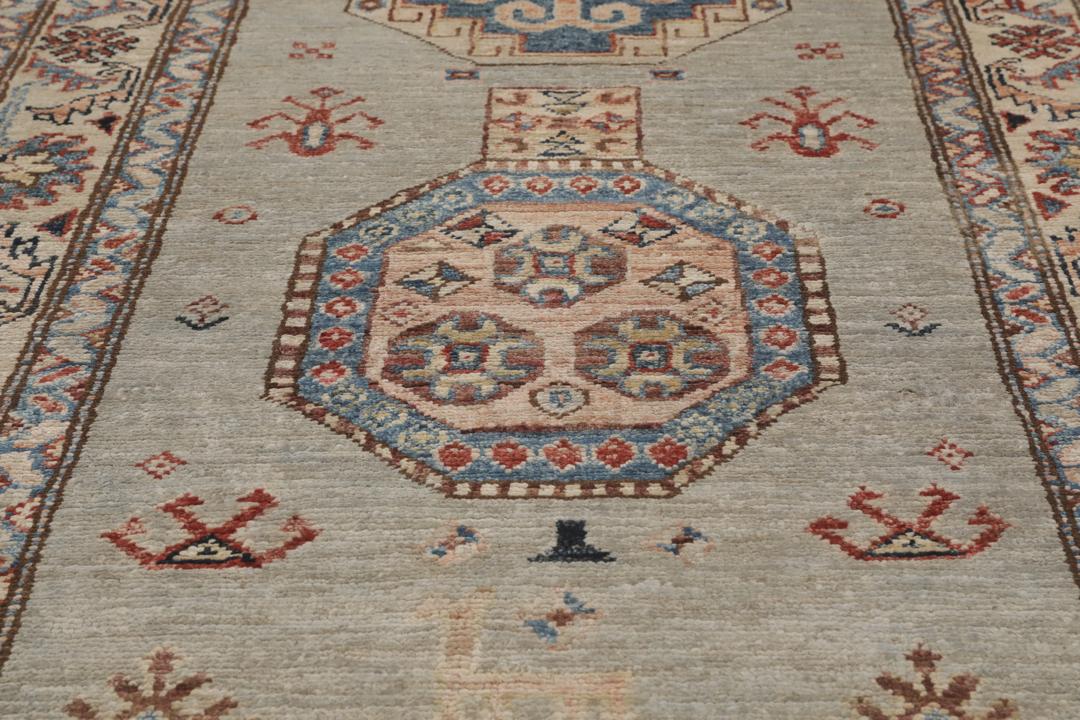 Alfombra pasillo de Oriente Medio anudada a mano con medallones geométricos en tonos grises, azules y rojos.