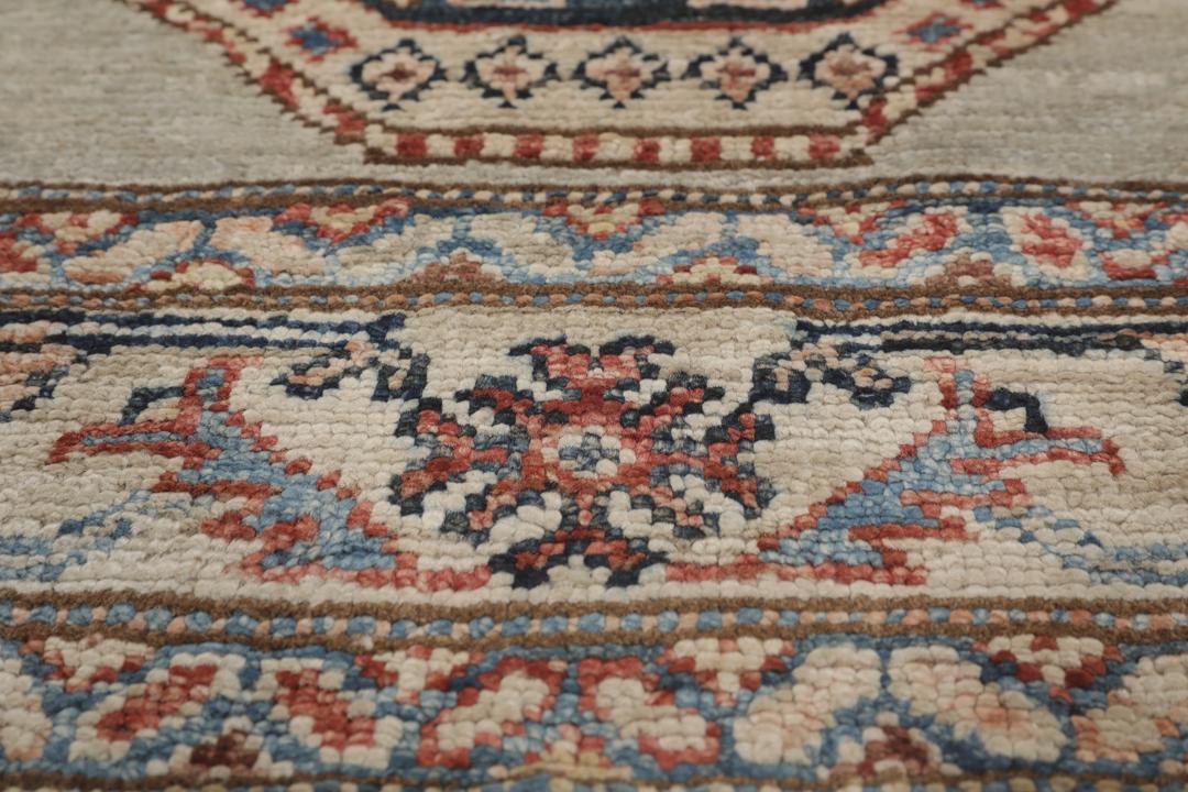 Alfombra pasillo de Oriente Medio anudada a mano con medallones geométricos en tonos grises, azules y rojos.