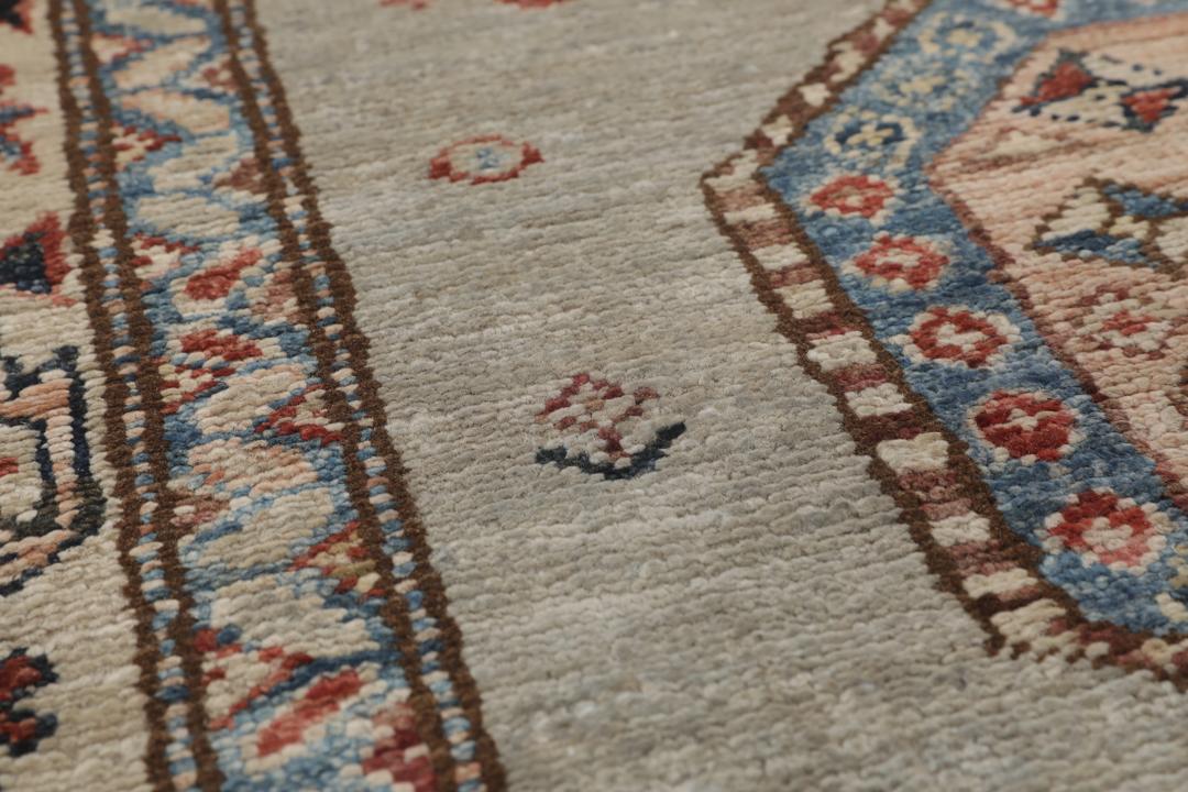 Alfombra pasillo de Oriente Medio anudada a mano con medallones geométricos en tonos grises, azules y rojos.