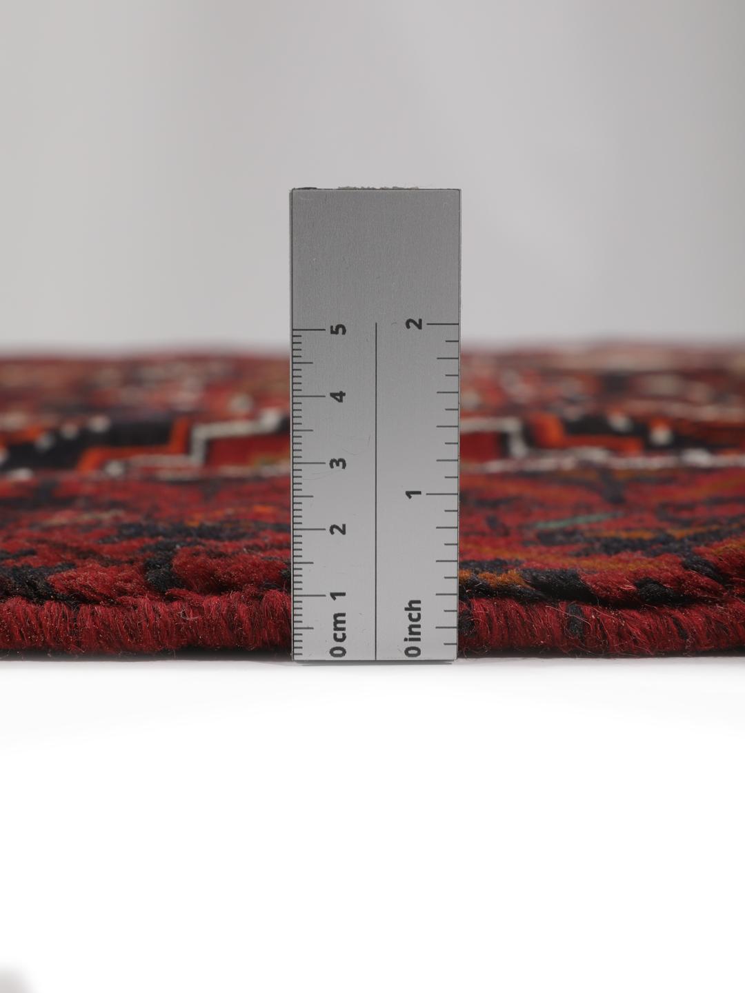 Handgeknoopt Beluch-tapijt met geometrische motieven in donkerrode en zwarte tinten.