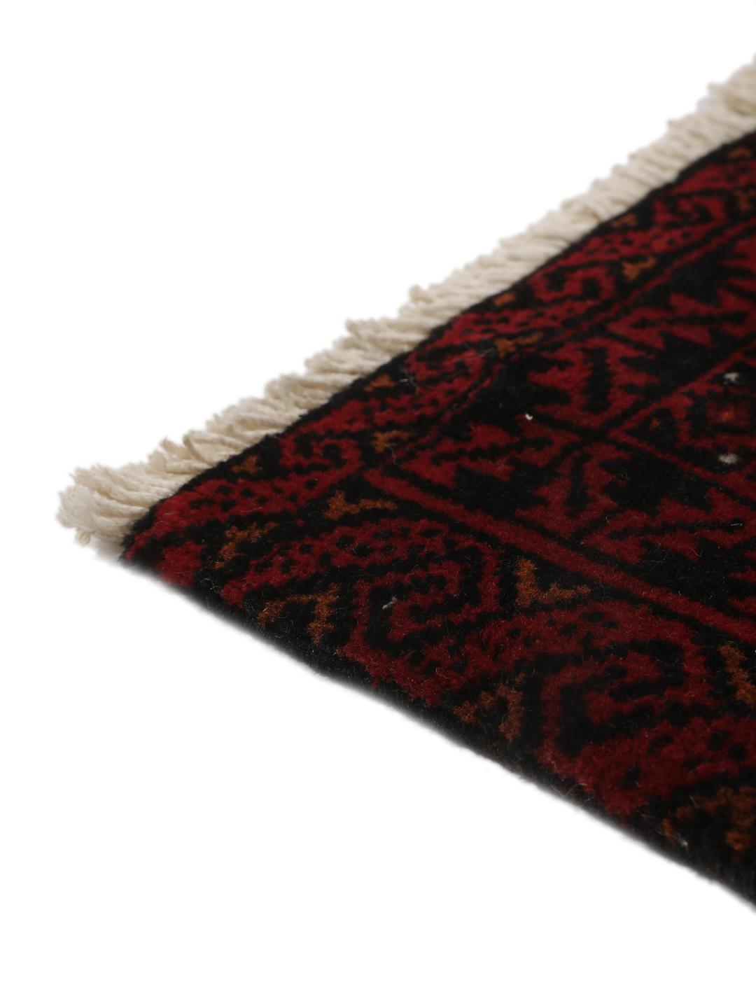 Handgeknoopt Beluch wollen tapijt uit het Midden-Oosten met een donkerrood geometrisch patroon.