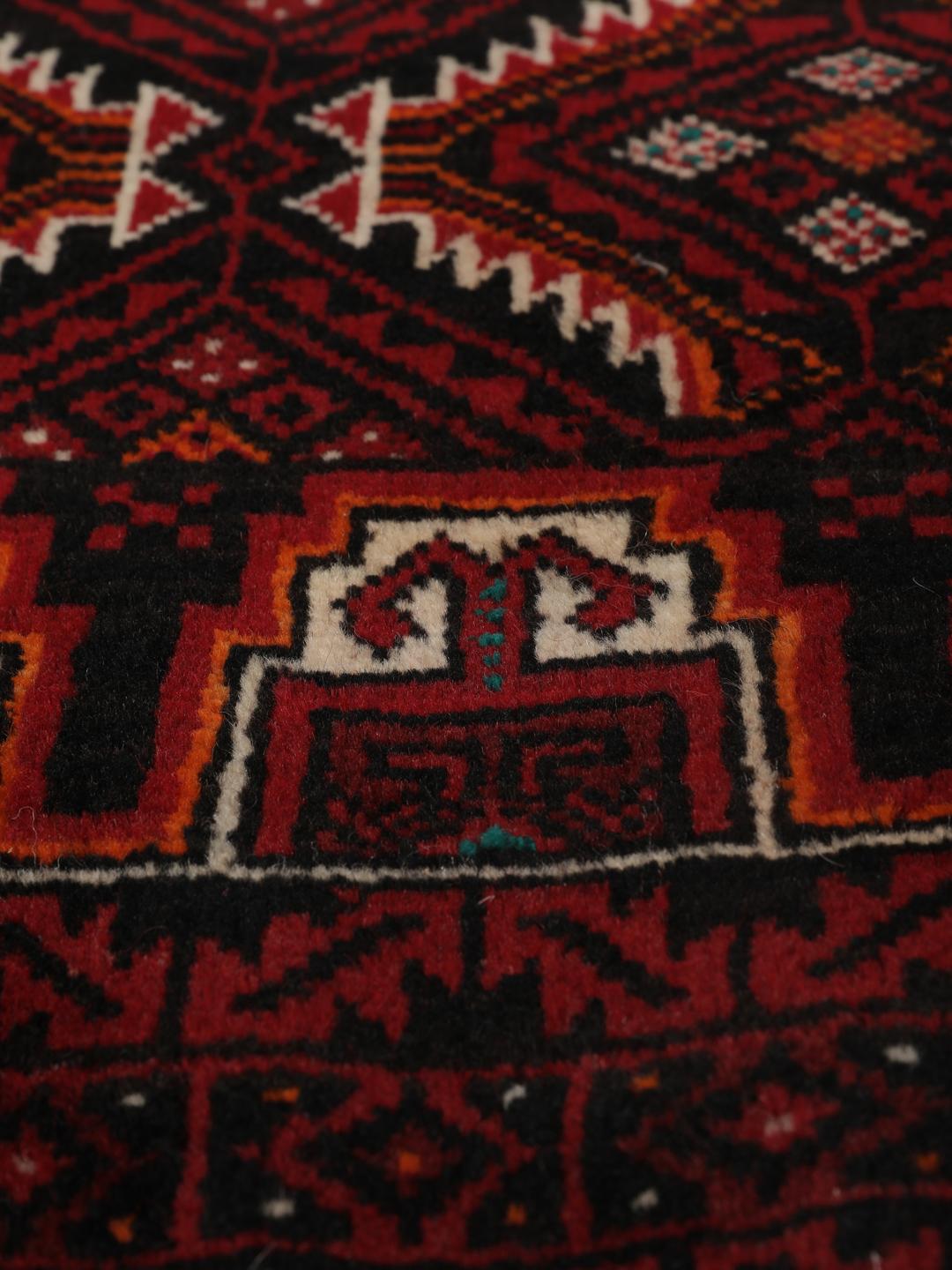 Handgeknoopt Beluch wollen tapijt uit het Midden-Oosten met een donkerrood geometrisch patroon.