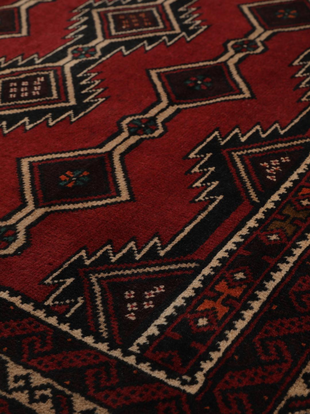 Hand-knotted Middle Eastern Baluch rug in dark red with geometric patterns
