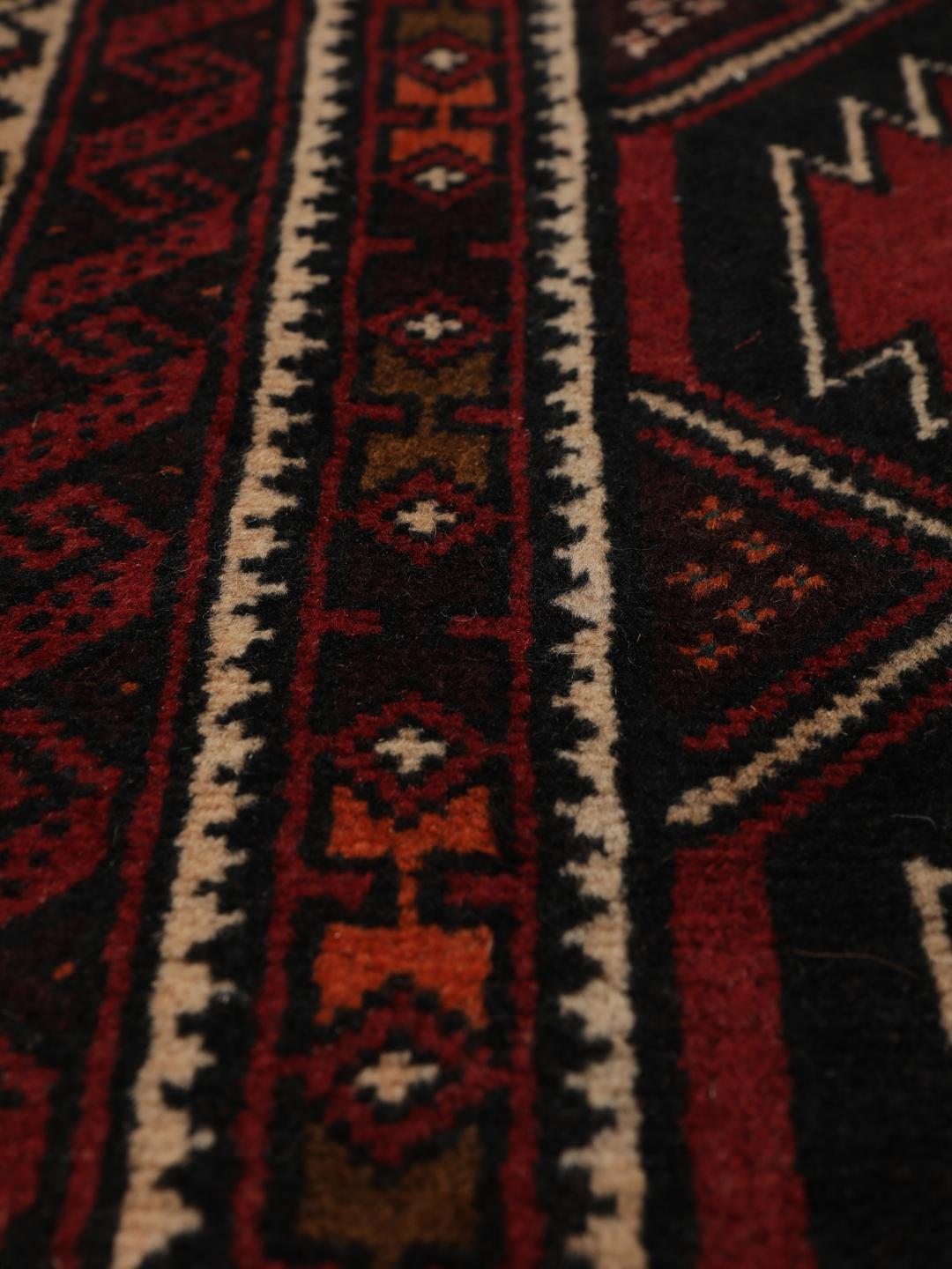 Hand-knotted Middle Eastern Baluch rug in dark red with geometric patterns