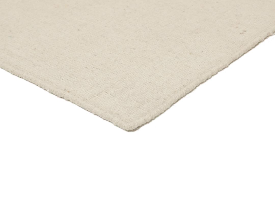 Um tapete Kilim tecido à mão, minimalista e de cor bege sólida, proveniente da Índia