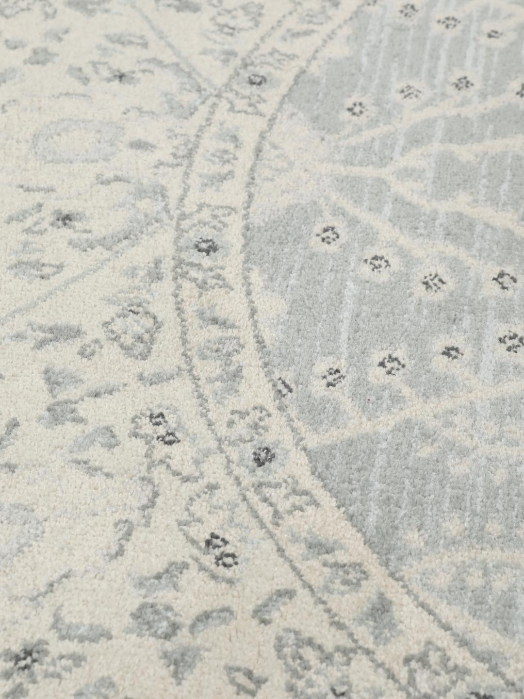Rond vloerkleed in lichtblauw en crèmekleurig beige met een traditioneel patroon