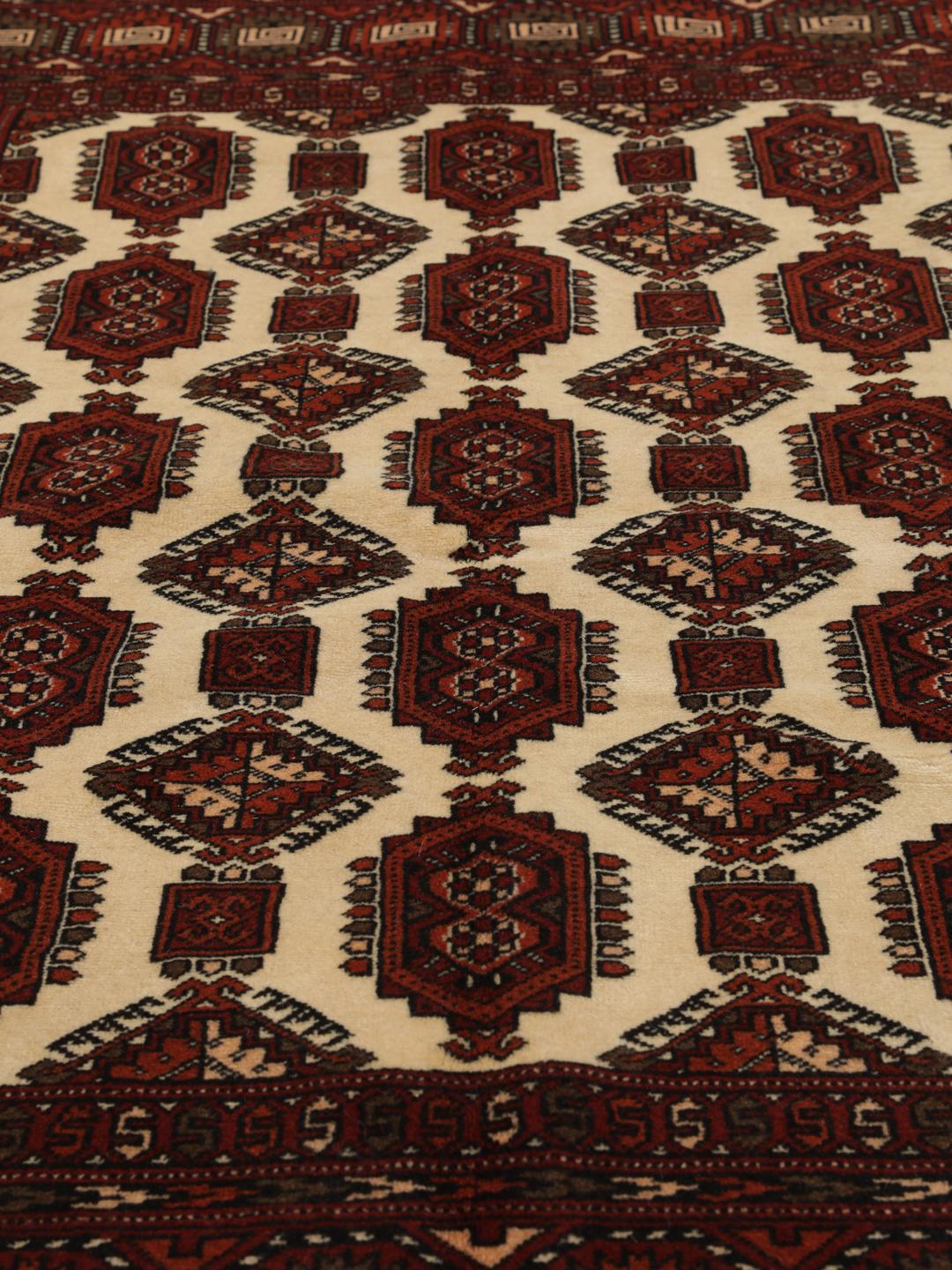Hand-knotted Turkaman rug from the Middle East featuring a vibrant red and cream colour palette