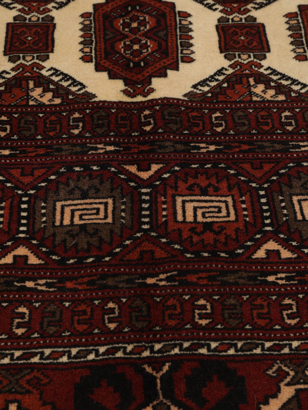 Hand-knotted Turkaman rug from the Middle East featuring a vibrant red and cream colour palette