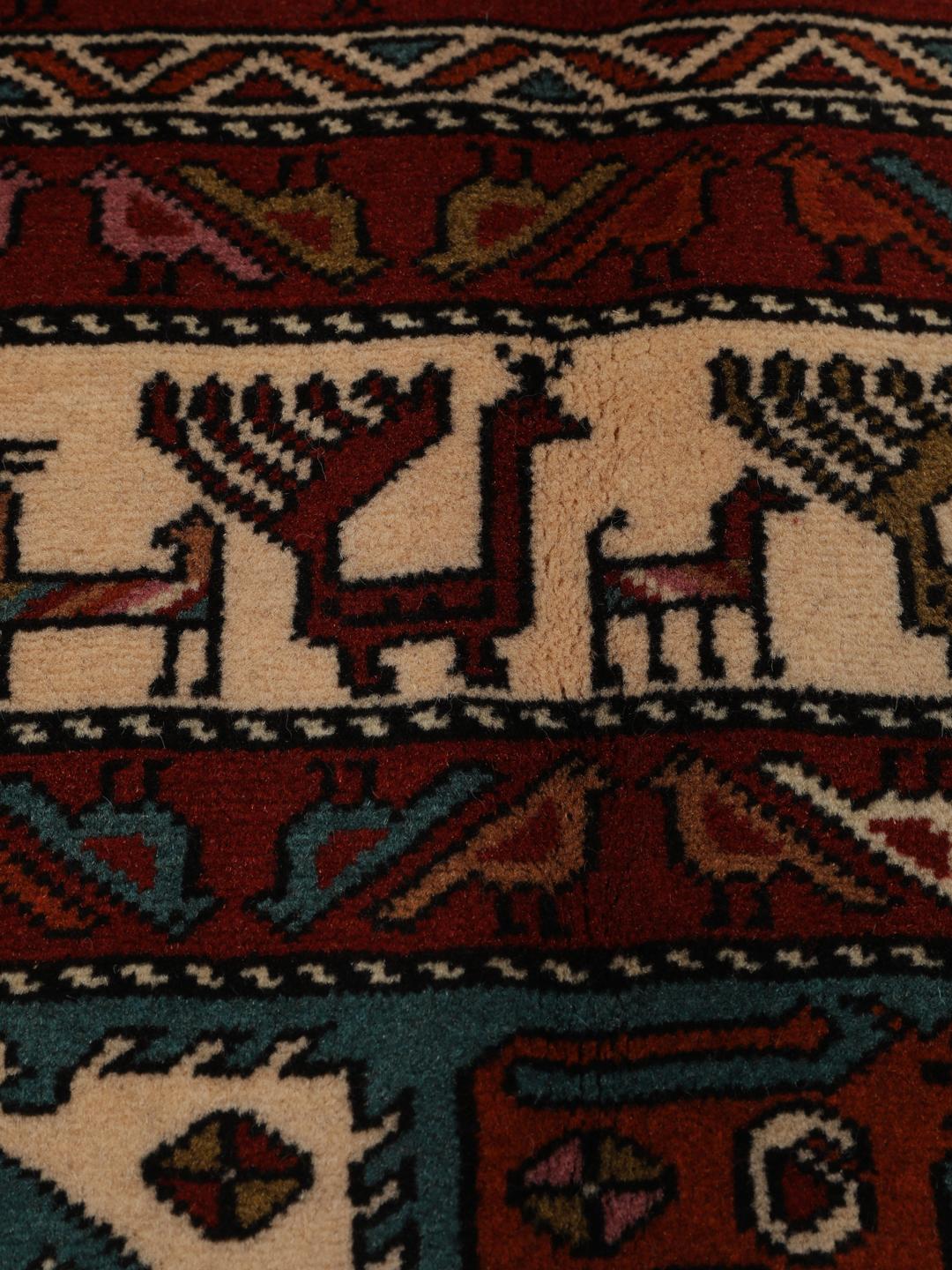 Hand-knotted Middle Eastern rug in red wool with pictorial motifs